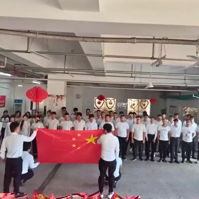 Workers assembly with two of them raising the chinese flag